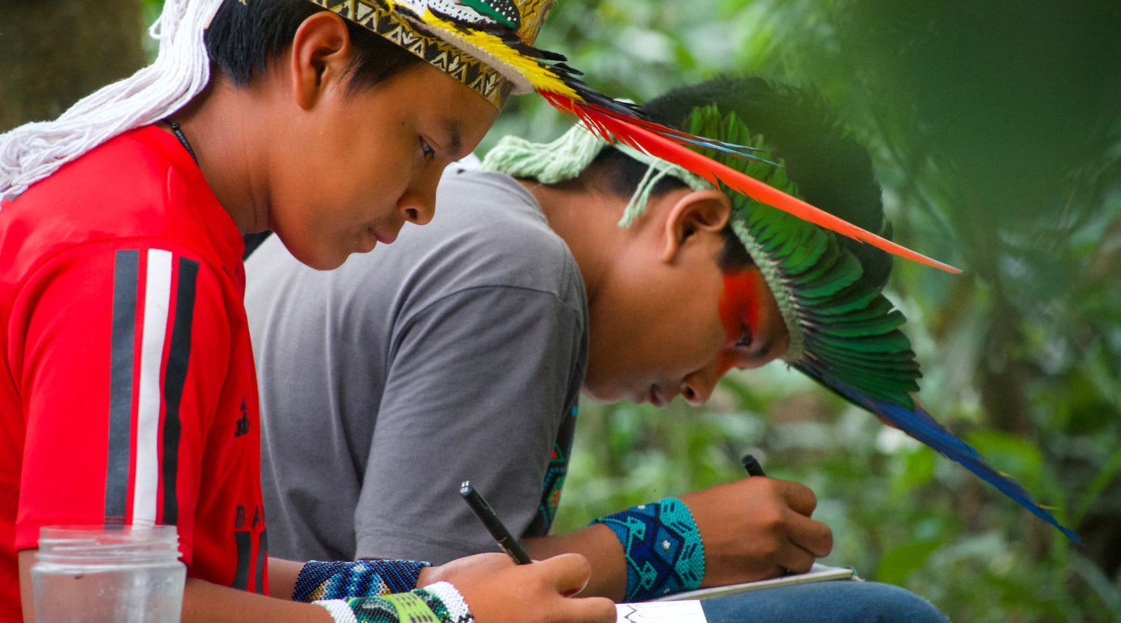 Two Amazon Indian artists drawing in the Amazon rainforest of Brazil