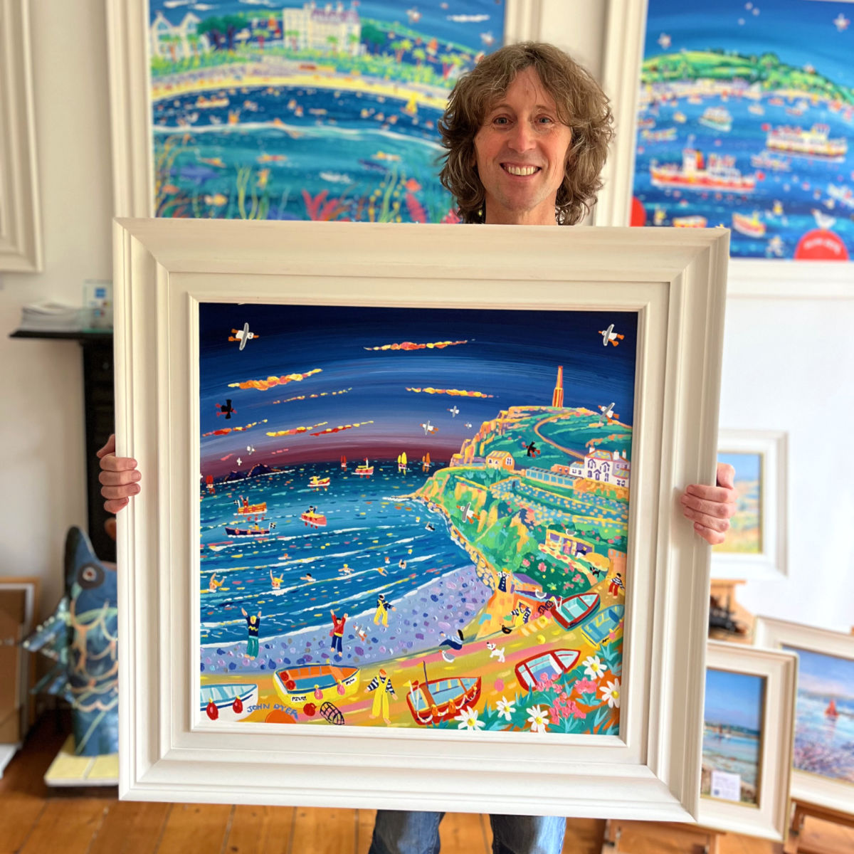 Cornish artist John Dyer pictured holding his painting 'Colourful Cape Cornwall', 24x24 inches acrylic on canvas.