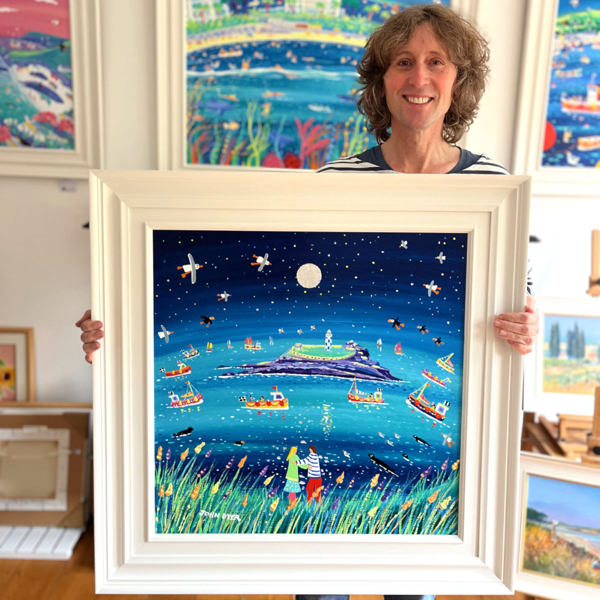Cornish artist John Dyer pictured holding his painting 'Under the Light of the Silvery Moon, Godrevy', 24x24 inches acrylic on canvas.