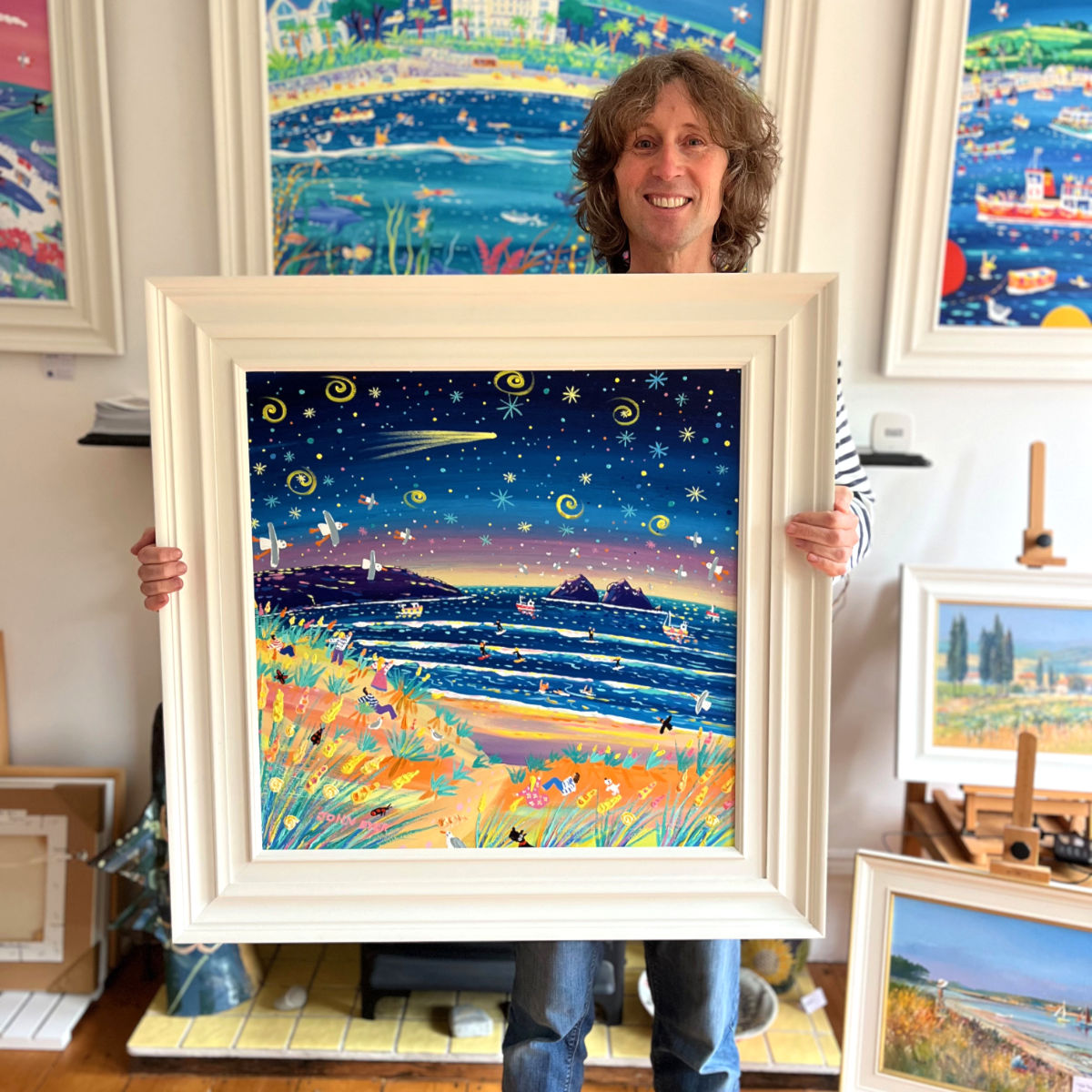 Cornish artist John Dyer pictured holding his painting 'Celestial Night, Holywell Bay', 24x24 inches acrylic on canvas.
