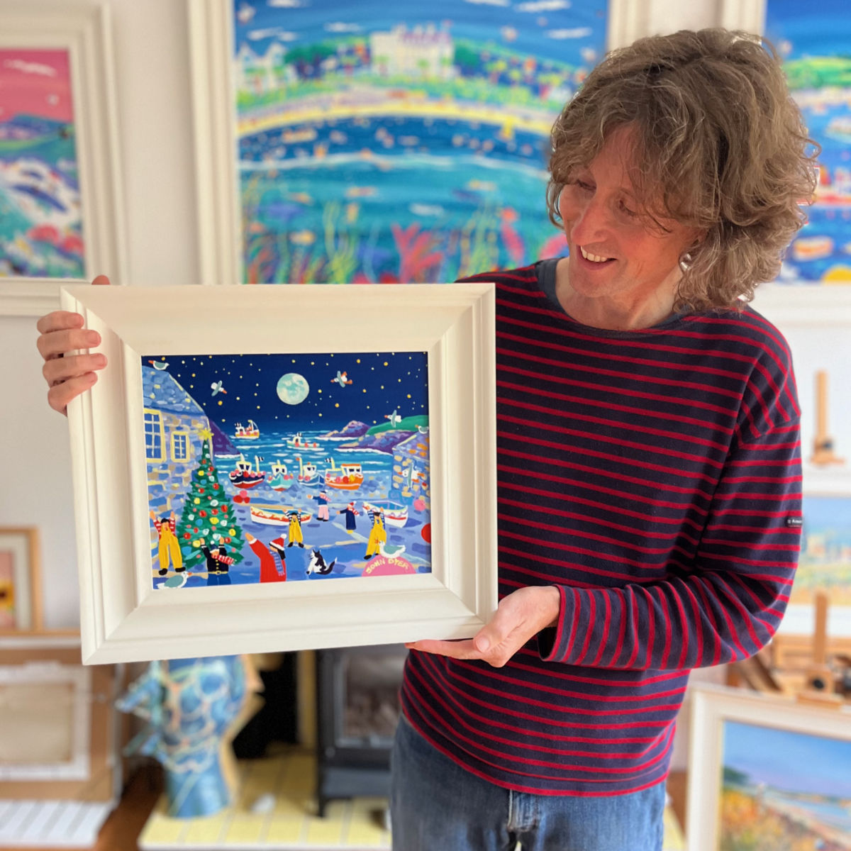 Cornish artist John Dyer pictured holding his painting 'Cadgwith Christmas', 10x12 inches acrylic on canvas.