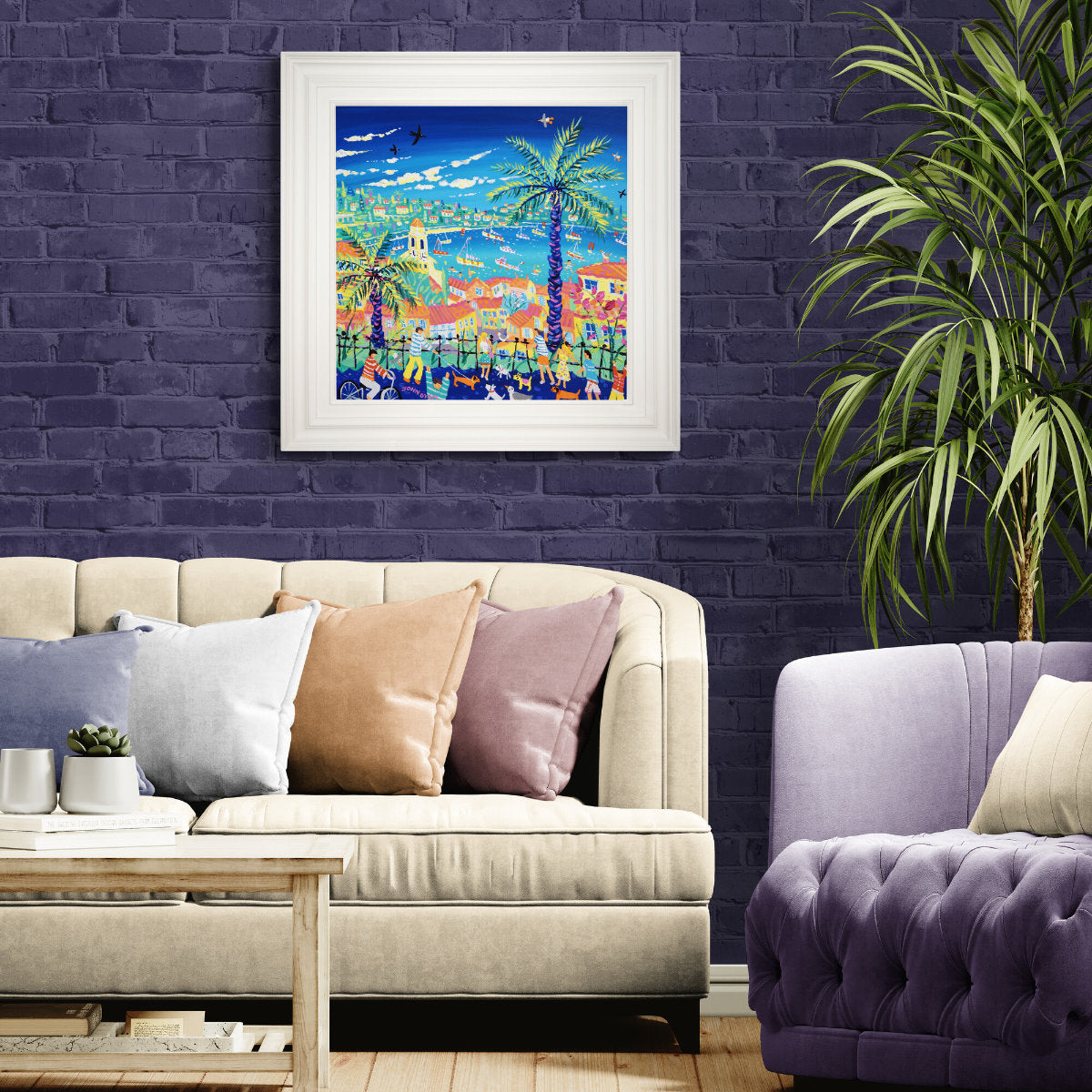 Colorful abstract painting on a purple brick wall above a beige sofa with decorative pillows. 'Palm Trees and Promenades, Villefranche-sur-Mer, France', 24x24 inches acrylic on canvas. French Painting by British Artist John Dyer