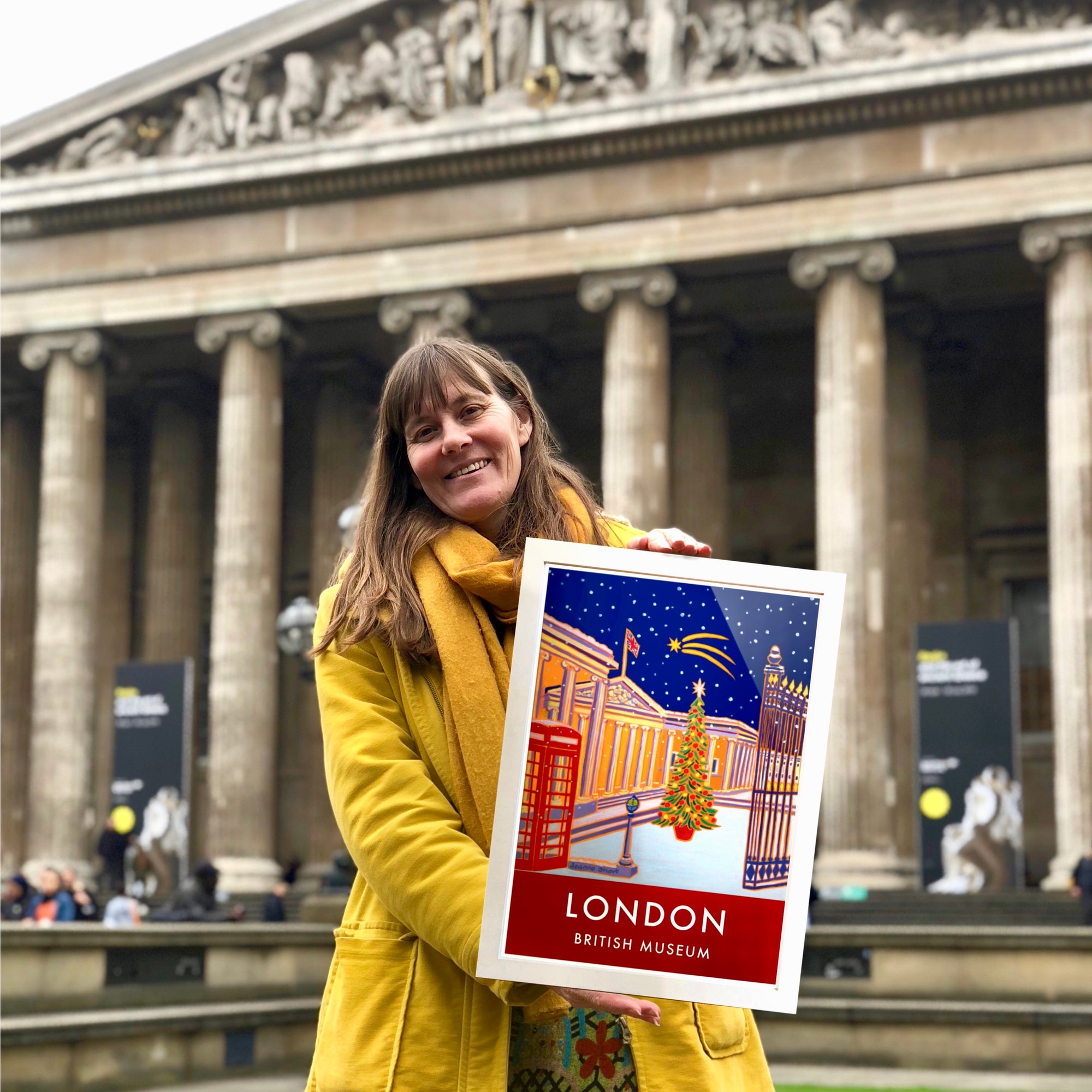 Artist Joanne Short outside the British Museum in London holding one of her new art prints of the museum which forms part of the new range of licensed art products featuring Joanne Short's art.