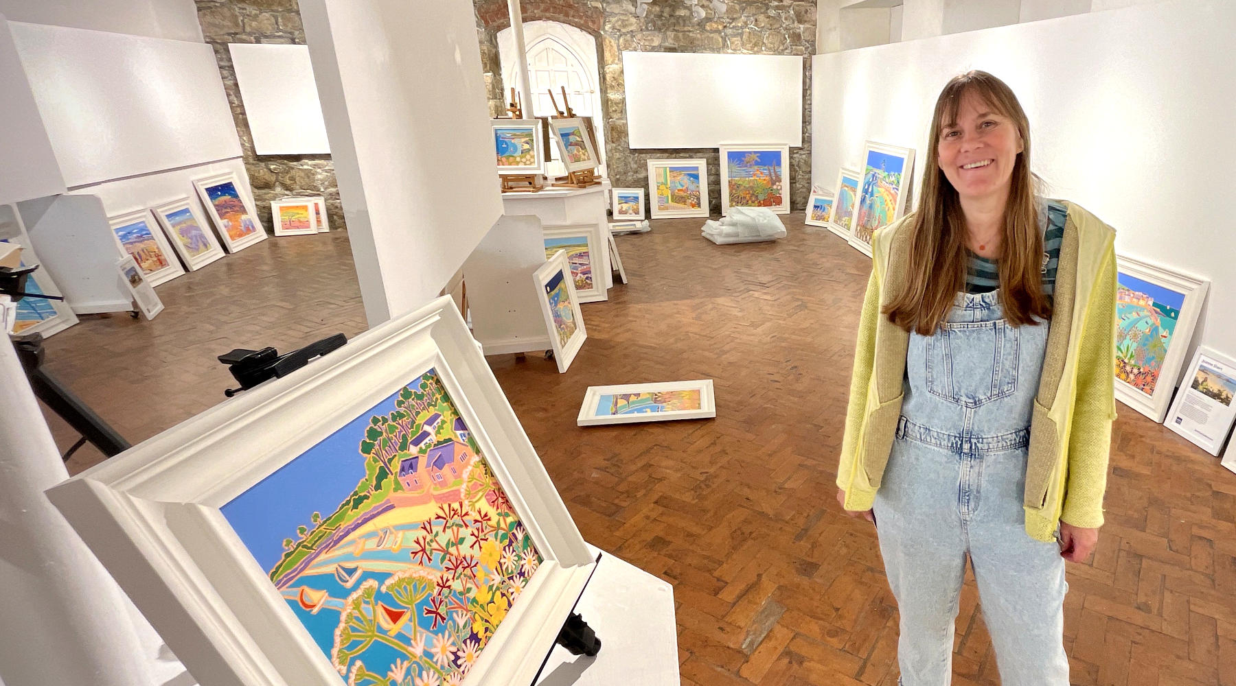 Cornish artist Joanne Short hanging an exhibition of new paintings in St Ives at the St Ives Society of Artists