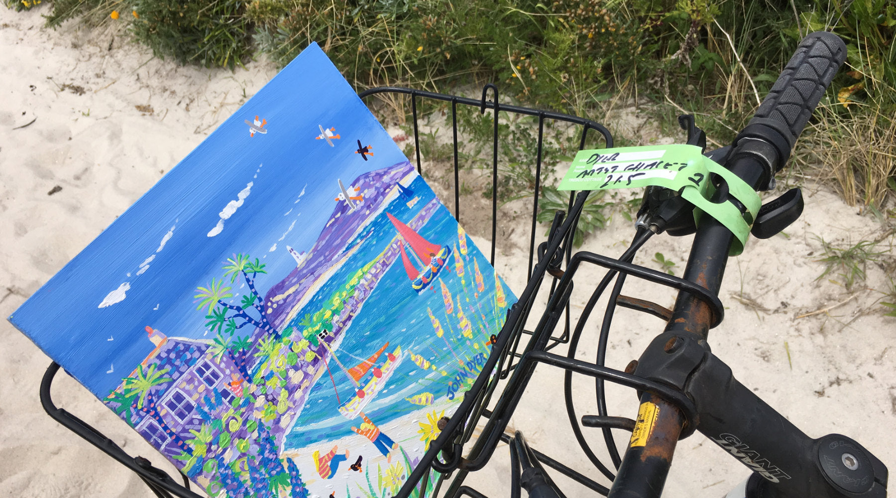 John Dyer painting of the beach pictured in a bike basket on the island of Tresco, Cornwall