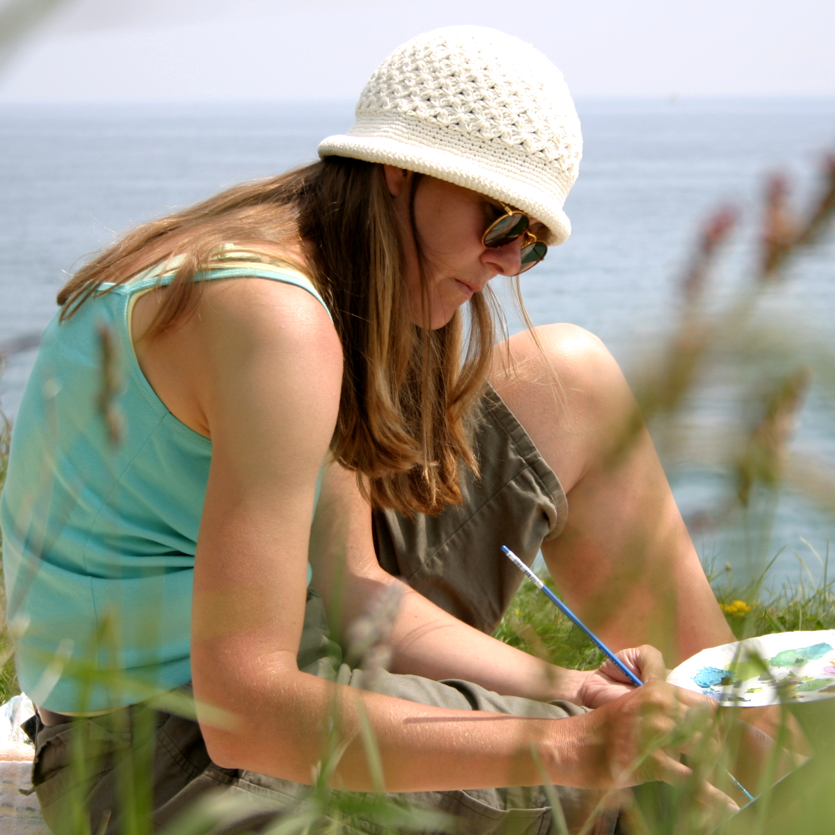 Artist Joanne Short pictured painting on the cliffs of Cornwall