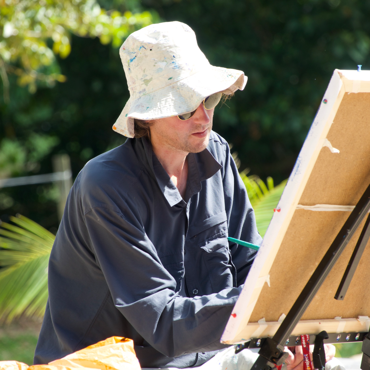 Artist John Dyer painting in the Amazon rainforest at his easel