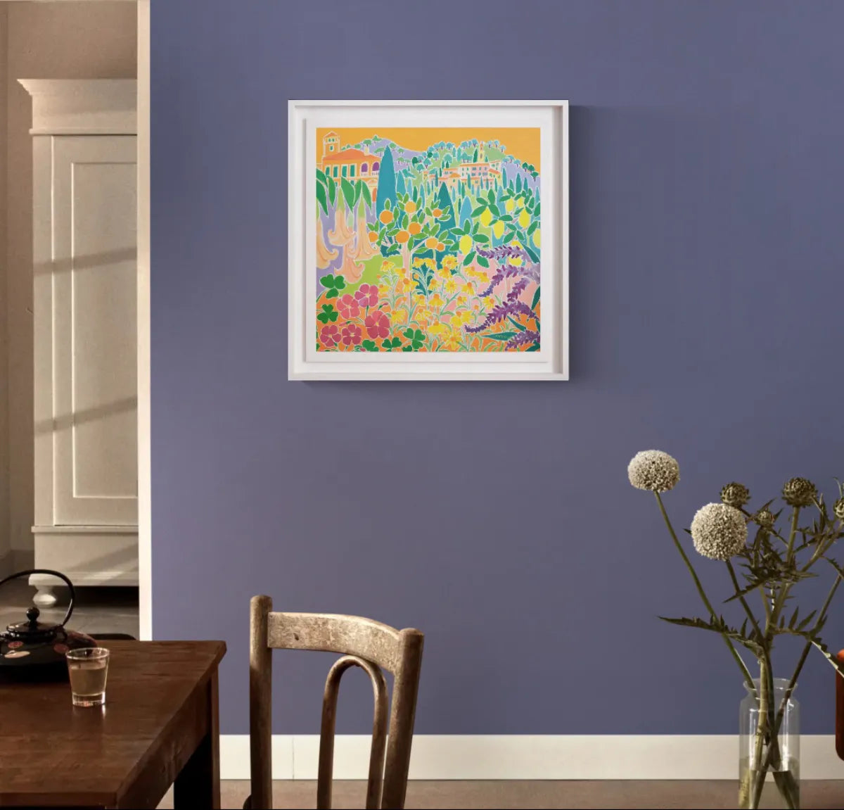 Colorful abstract painting on a blue wall above a wooden chair. Original Painting by Joanne Short. 'Singing and Zinging, Hanbury Garden, Italy'. 24 x 24 inches oil on canvas