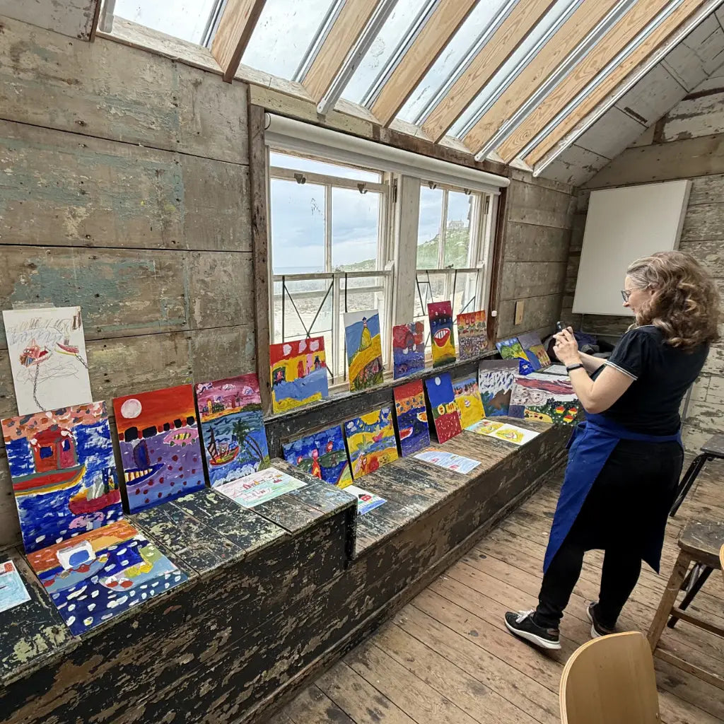 Cat, the education orgniser from the St Ives School of Painting, photographing acrylic paintungs created during a Fauve John Dyer art workshop in the Porthmeor Studios.