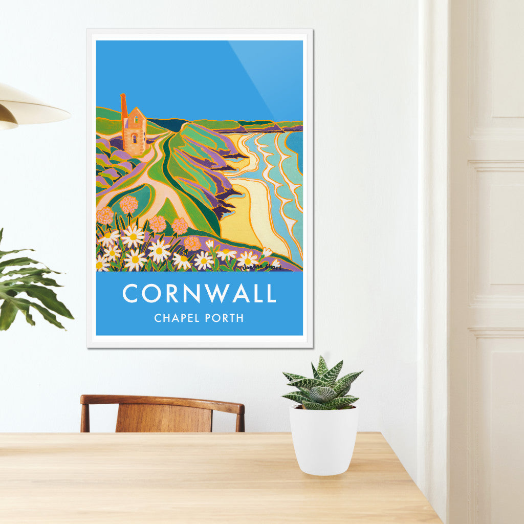 Cornwall framed wall art poster print of Chapel Porth Tin Mine at St Agnes by Cornish artist Joanne Short. The Cornish tin mine of Wheal Coates, at Chapel Porth St Agnes, is the subject of the painting by Joanne Short that is featured on this stunning art poster print. The beautiful blue Cornish sky sets off the warm colours of the brick work in the old engine house beautifully. Wild flowers feature in the print and the waves roll into the shore along the coast and coastal path.