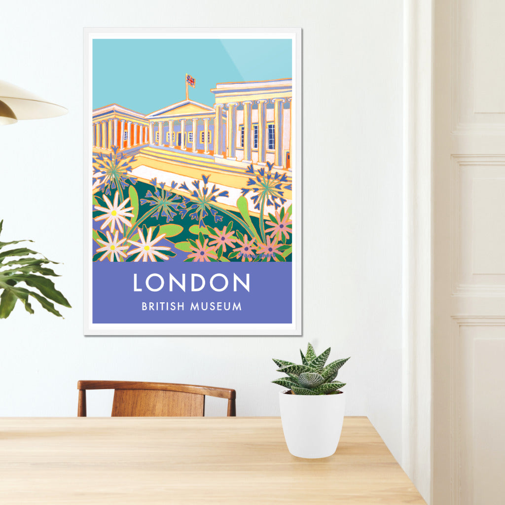Framed London archival wall art poster print of the British Museum by artist Joanne Short. The wonderful architecture of the British museum have been captured by artist Joanne Short in the painting that features on this archival wall art London poster print.Agapanthus flowers fill the foreground and a British Union jack flag flutters on the roof of the museum. A perfect souvenir archival wall art poster of London for your home, office or holiday rental.