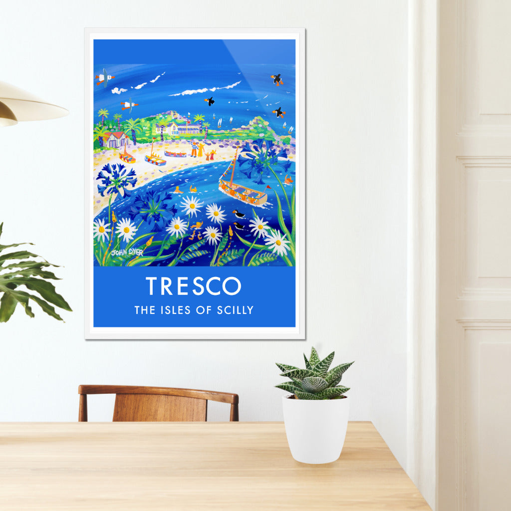 This vintage style wall art poster print of Tresco on the Isles of Scilly features a painting by renowned Cornish artist John Dyer. Using colour and type the print creates a vintage feel while offering the best of Cornish contemporary art. Stunning blue colours, a blue and turquoise sea with blue agapanthus flowers &amp; white moon-daisies. A family wave from the beach on Tresco &amp; puffins and seagulls fly through the sky. Available unframed or framed ready for your wall.