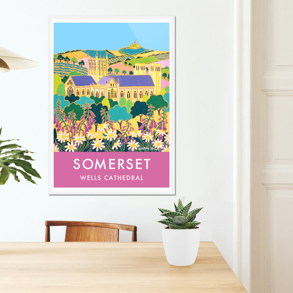 Wall art poster print of Wells Cathedral, Glastonbury Tor and the Somerset landscape by artist Joanne Short with pink foxgloves and wildflowers. A wonderful image of the Somerset landscape looking through wildflowers towards Wells Cathedral and then Glastonbury Tor beyond. Artist Joanne Short&#39;s painting &#39;Springtime Flowers, Wells&#39; is beautifully reproduced on this vintage style travel art poster and is available framed or unframed in a range or sizes to fit your home or office.