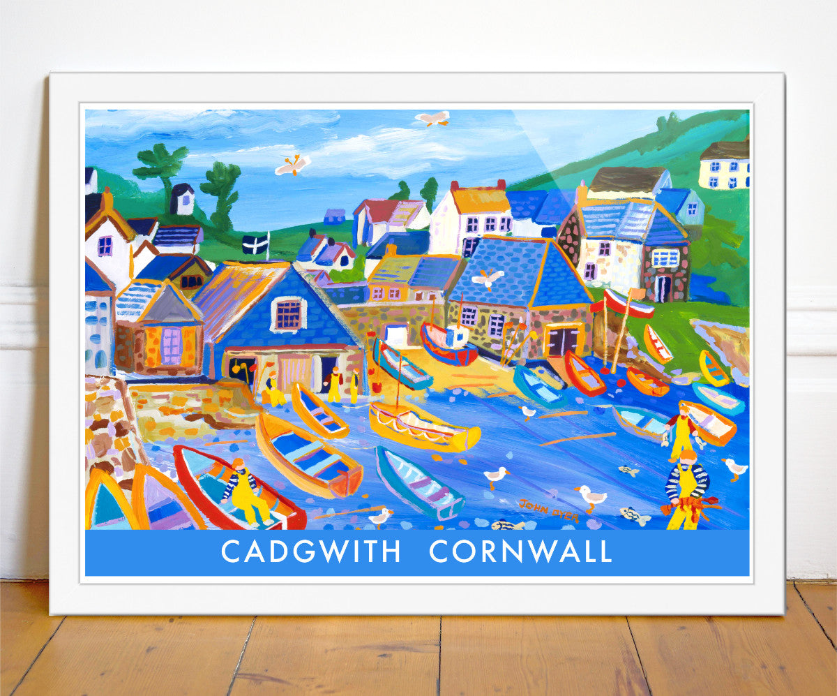 One of John Dyer&#39;s most famous paintings of Cadgwith is now available on this seaside vintage style travel fine art poster print. John&#39;s work is combined with vintage style type &amp; block colour. Fishing boats crowd the beach at Cadgwith Cove on the Lizard in Cornwall. Fishermen catch lobsters and fish and seagulls zoom through the sky. A Cornish flag flies over the boat house. A brilliant art poster of Cornwall that is supplied unframed or framed in a wide variety of sizes.